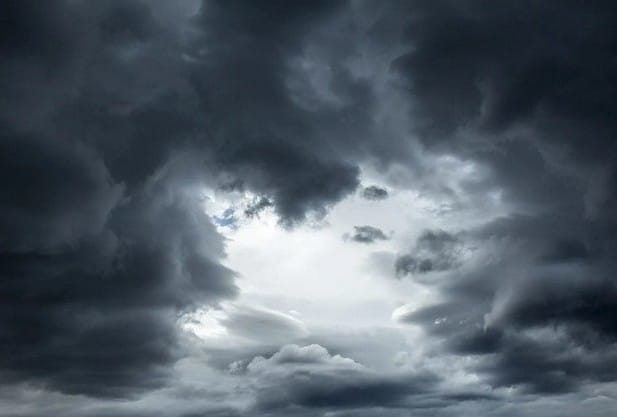 A sky with clouds, representing the emotional turmoil that lingers after physical change. 